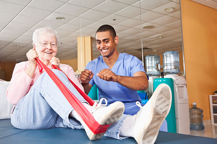 A senior woman uses a resistance band during physical therapy in Bossier City