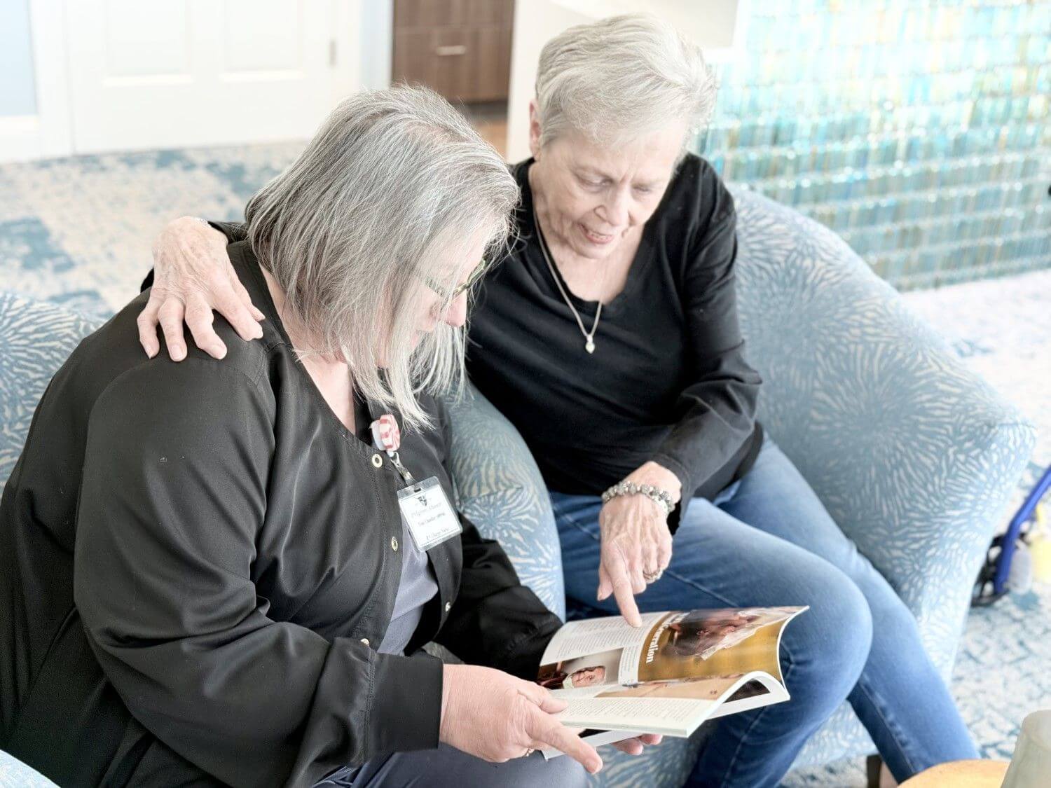 Two women on a couch reading a magazine on post-surgery skilled nursing in Bossier City, LA
