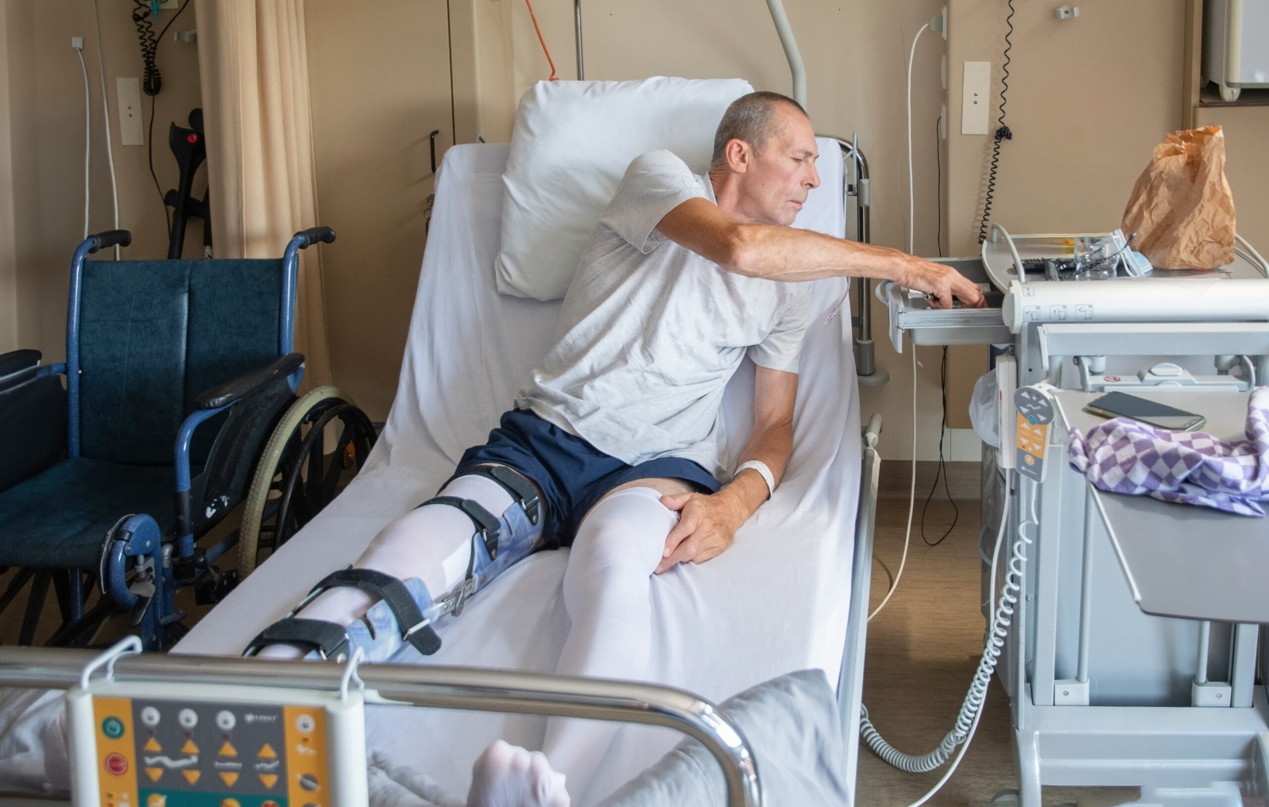 a man with a broken leg in an orthosis on a bed in a clinic after an accident and a fracture of the femur