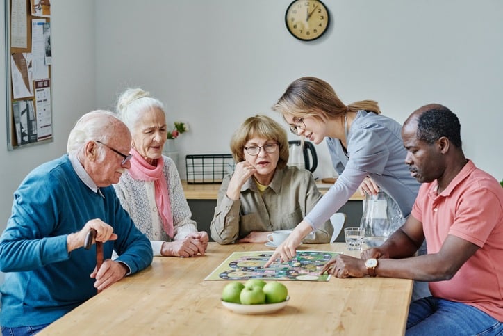 Group of seniors playing a board game in dementia care