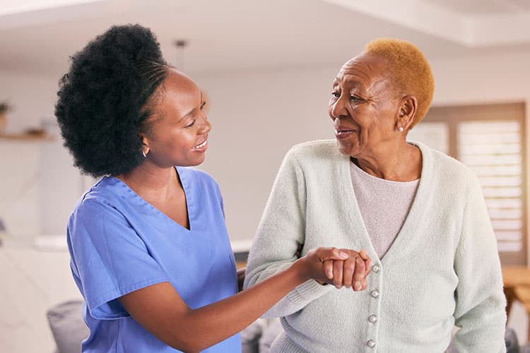 Senior woman assisted in her room by a respite care nurse
