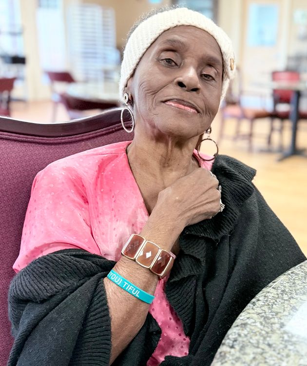 Caregiver supporting a smiling senior resident